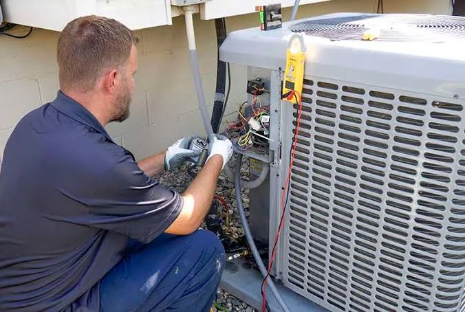 Technician diagnosing a residential air conditioning condenser